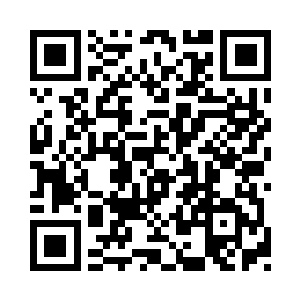 一个人指着远处一个出来到小卖店买东西的二维码生成