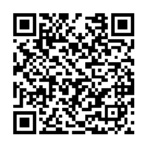一个眼神锐利的青年在房子外边拿出手机开始说话二维码生成