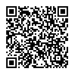 一个穿着礼服的漂亮女孩挽着一个身穿着黑色礼服的年轻人从楼梯上走了下来二维码生成