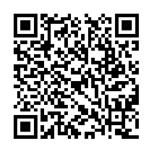 一个笑嘻嘻的胖子从一张桌子下提起一个大黑坛子二维码生成