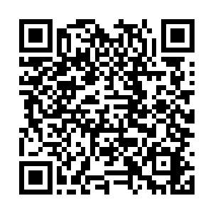 一个缩在座位上不停在本子上写着什么的年轻男人二维码生成