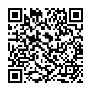 一个身穿深蓝色西装脖子上扎着围巾的男人走了进来二维码生成