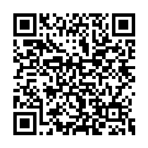 一个黑衣男子将一张地图铺在了碑亭内的石桌上二维码生成