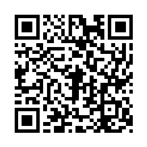 一名戴着老花眼镜的专家盯着眼前一台电脑二维码生成