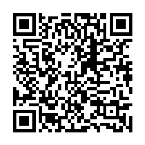 只见一个五官深邃相貌姣好的青年男子正拿着谜面二维码生成