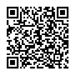 只见一个身着黑色大衣和牛仔裤的黑发时尚帅哥大步地跑来二维码生成