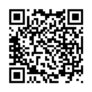 易傲风弯腰捡起地面上的草和树叶二维码生成