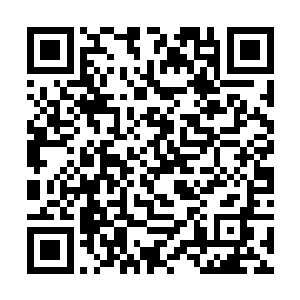 苏鲁族年轻头人蹲在山腰一块大石头边有点跃跃欲试二维码生成