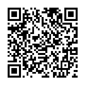 那位看上去大约能有六十岁上下的考官突然拿起手上的纸晃了晃二维码生成