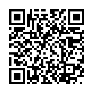 院子的围墙里晾着很多白布和染过的布二维码生成